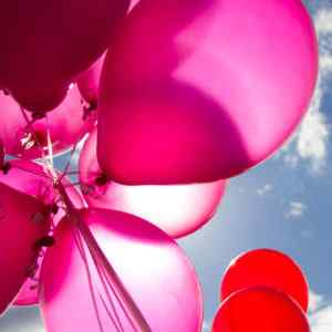 Pink balloons float in the sky in the Telephone Service Representative celebration day