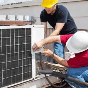 Two technicians working and saving money by using an HVAC answering service