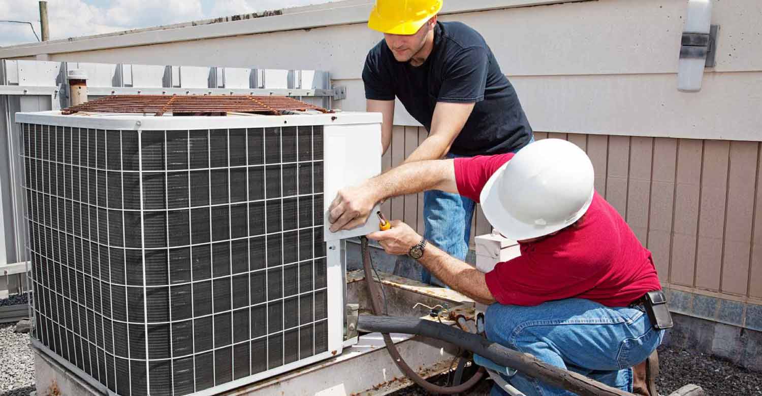 Two technicians working and saving money by using an HVAC answering service