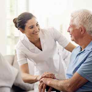 An old man smiling to a healthcare nurse who has chosen a Healthcare Specialized Answering Service