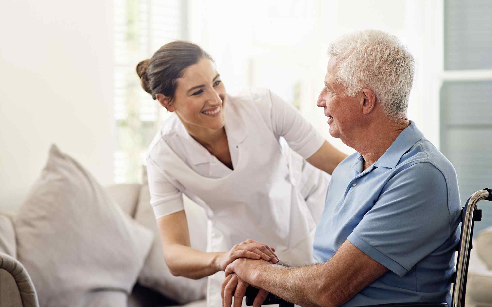 An old man smiling to a healthcare nurse who has chosen a Healthcare Specialized Answering Service