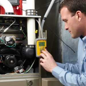 Heating and ventilation technician working after an emergency call from his HVAC answering service