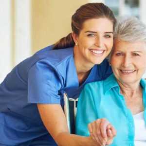 Old woman with homecare worker happy to have her phone covered by a Home Care Answering Service