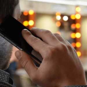 A man on the phone requesting information about hiring an answering service for his business