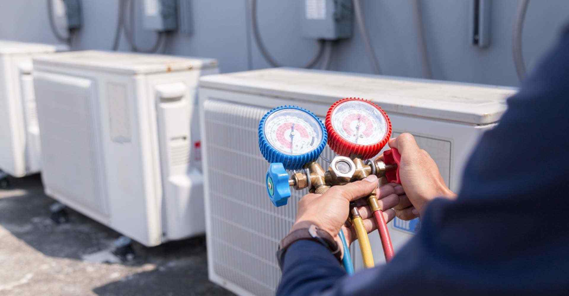 A technician working with tools while a Telephone Answering Service takes care of his HVAC business