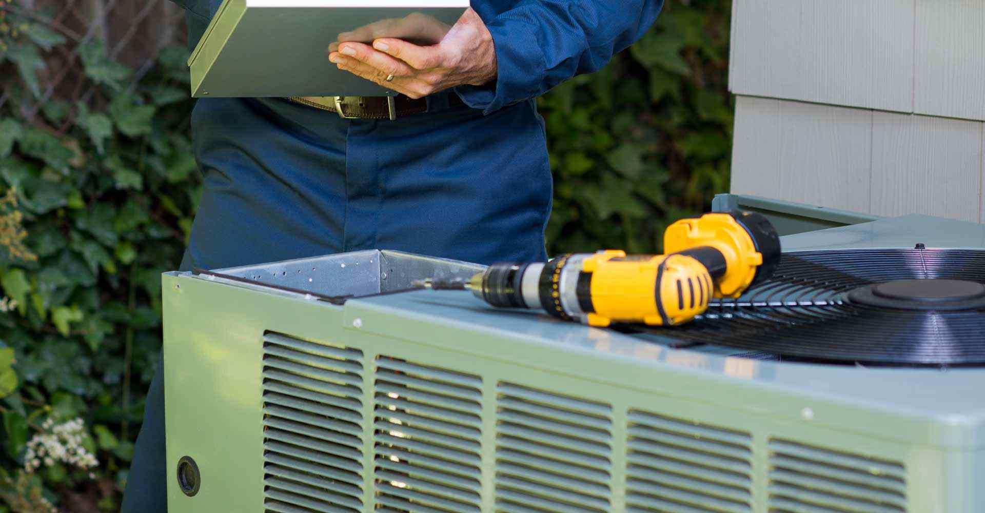 HVAC expert fixing an air conditioning unit on a call provided by his phone answering service