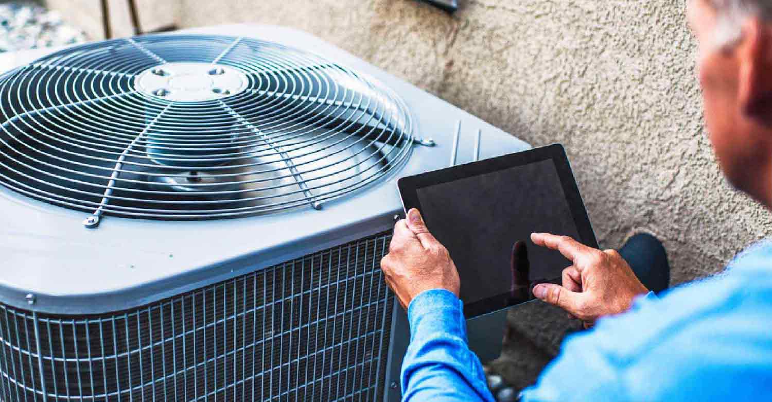 Worker checking the on-call scheduling from his answering service while repairing the HVAC system