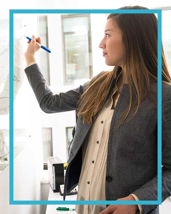 A girl writing on a white board during the answering service quality employee training