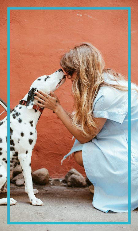 A woman pet owner cuddling his dog before the veterinarian visit