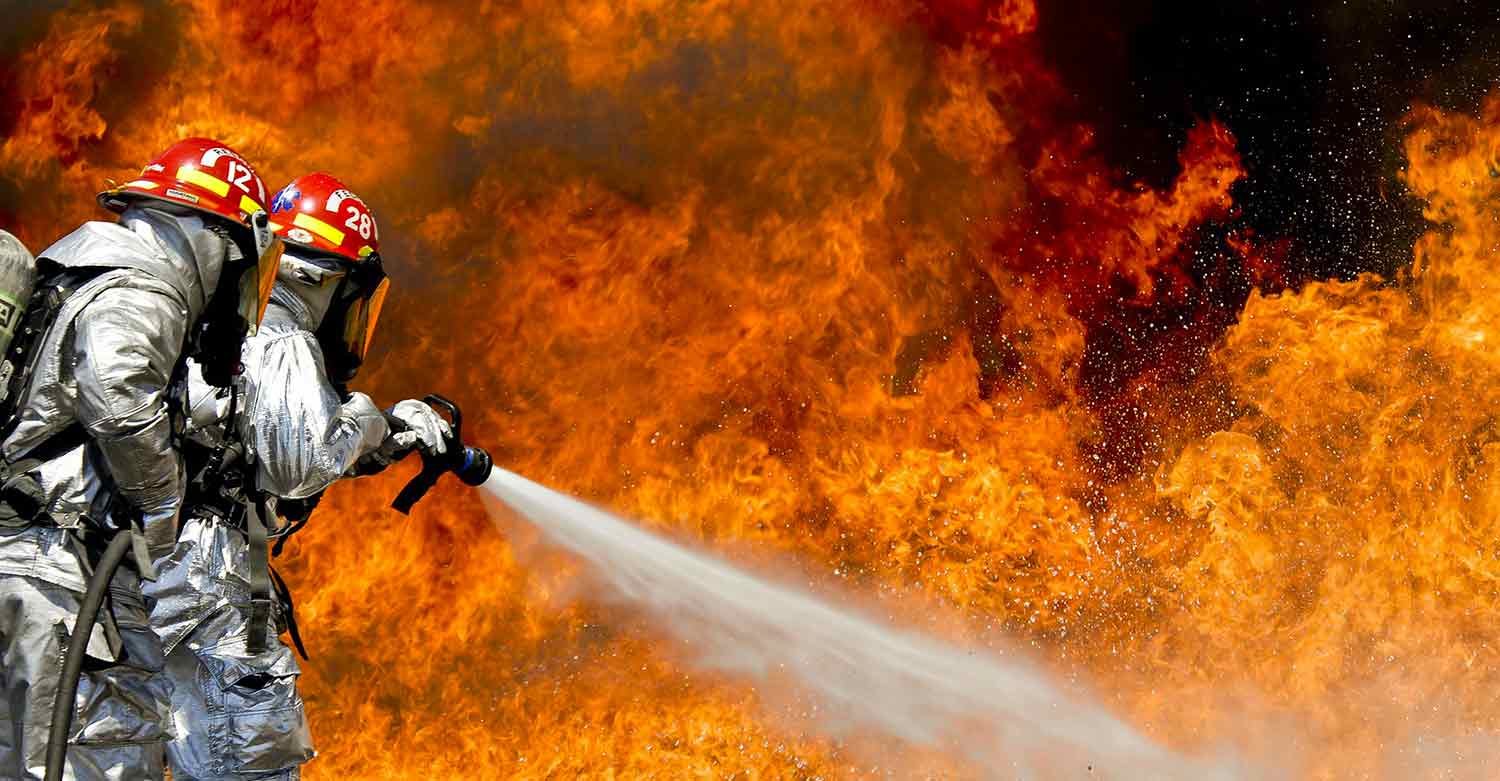 Firemen at work in a company on fire that will need the help of a disaster restoration business