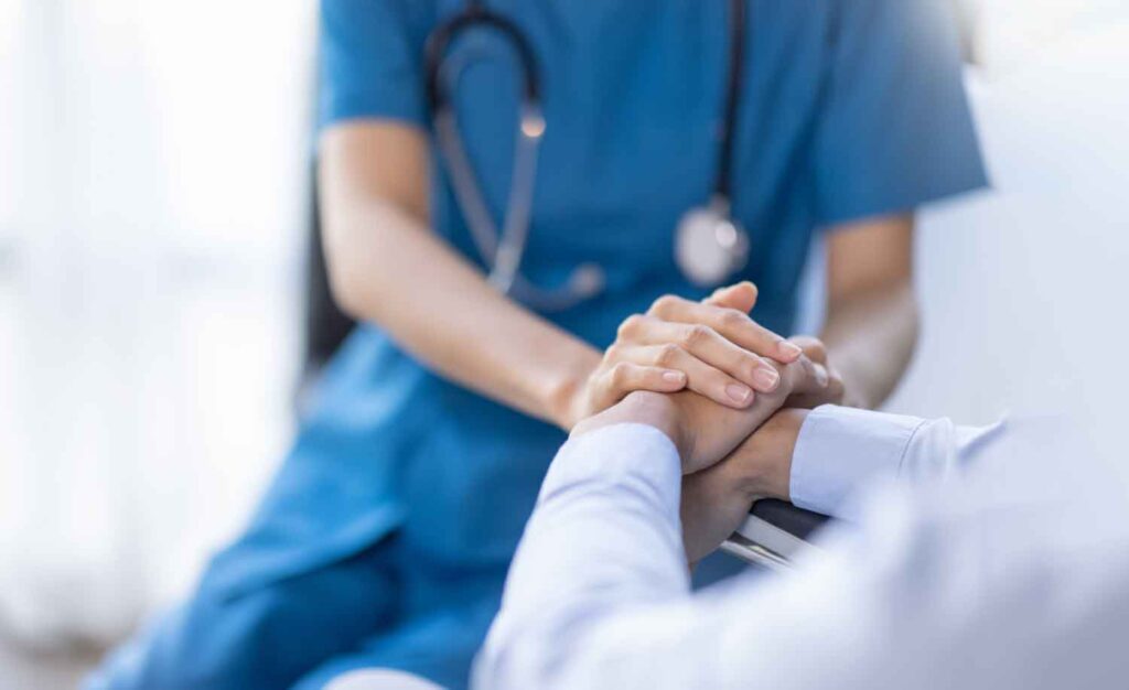 A hospice nurse shaking caring a customer helped by the 24/7 telephone answering service